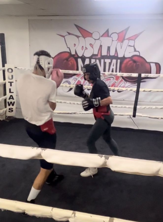 Sahar sparring in a boxing ring wearing headgear