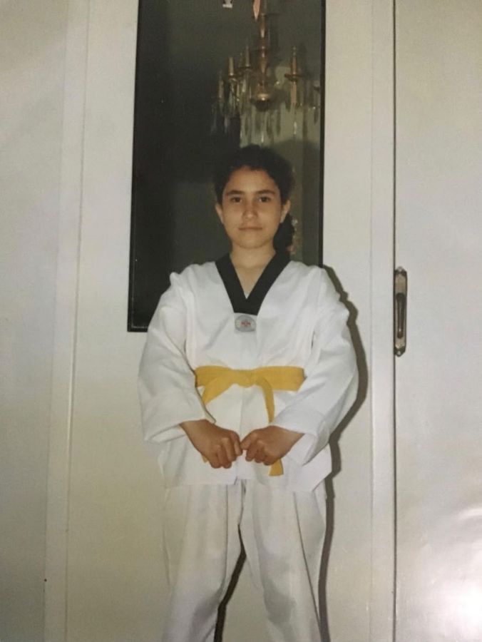 Sahar as a child in a taekwondo uniform with a yellow belt