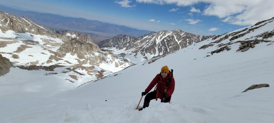Sahar climbing a steep snow slope on Mount Whitney with an ice axe